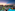 a pool with palm trees and a building with a beach and a sunset
