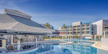 a pool with chairs and a bar in the background