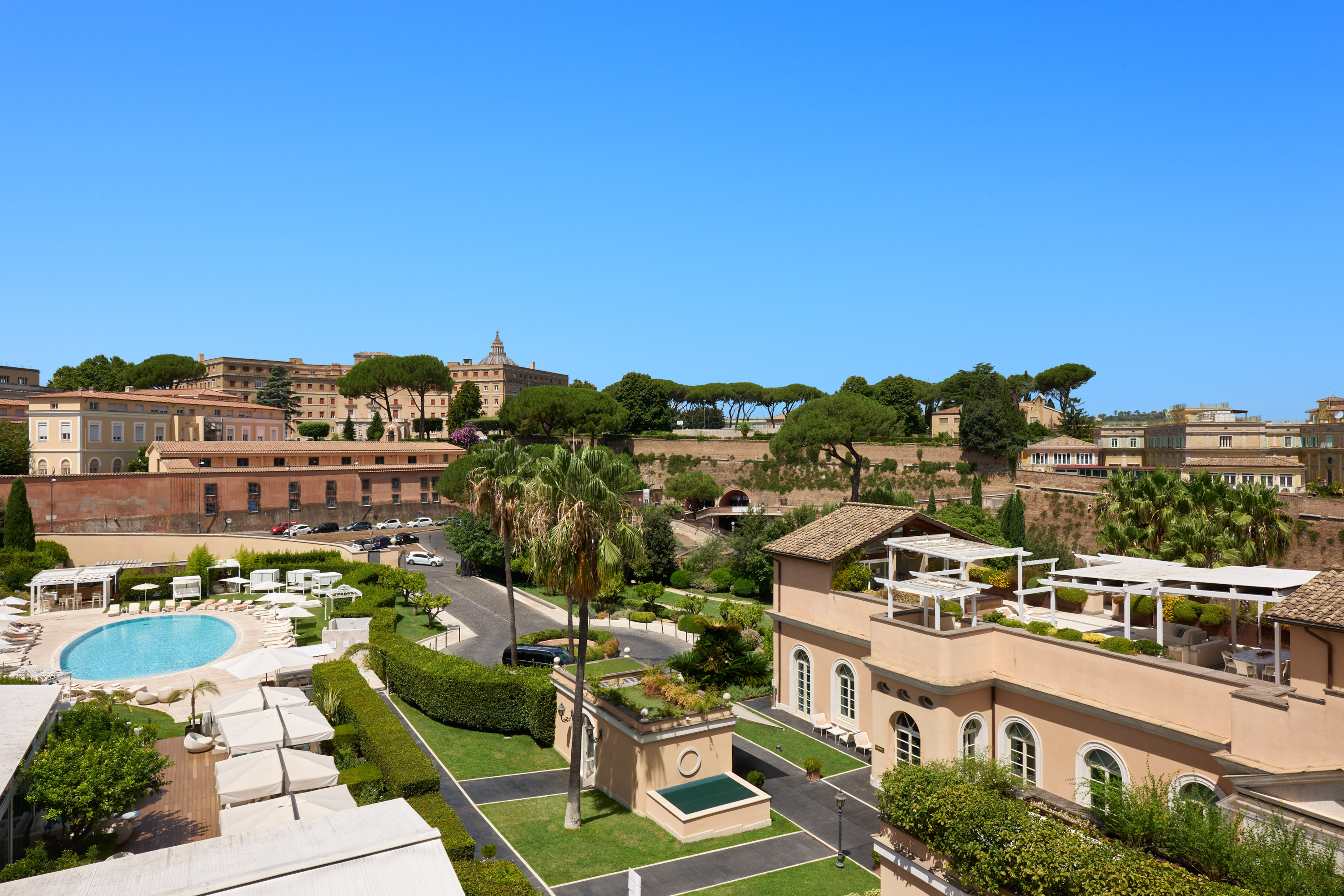 Aerial view of luxury hotel pool, gardens, and historic architecture in Rome.