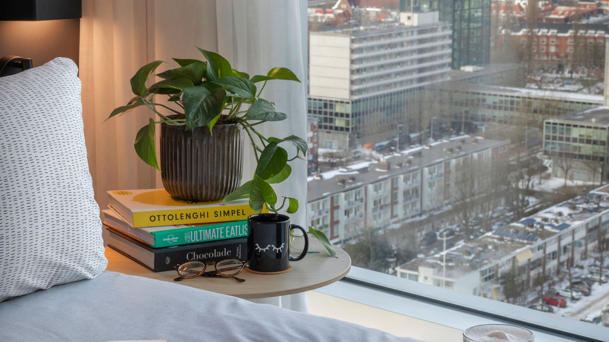 a breakfast in bed with a window overlooking a city