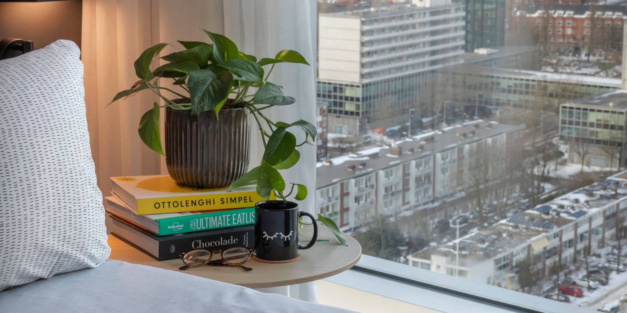a breakfast in bed with a window overlooking a city