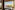 Hotel room window with Paris cityscape, Eiffel Tower, and Seine River view.