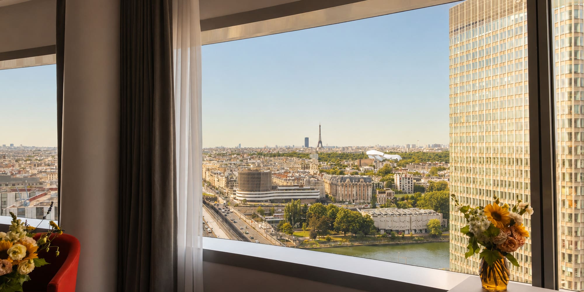 Paris high-rise hotel room with Eiffel Tower, Seine River, and city view.