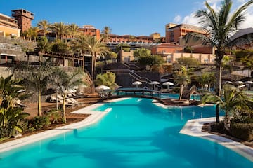 a swimming pool with palm trees and buildings in the background