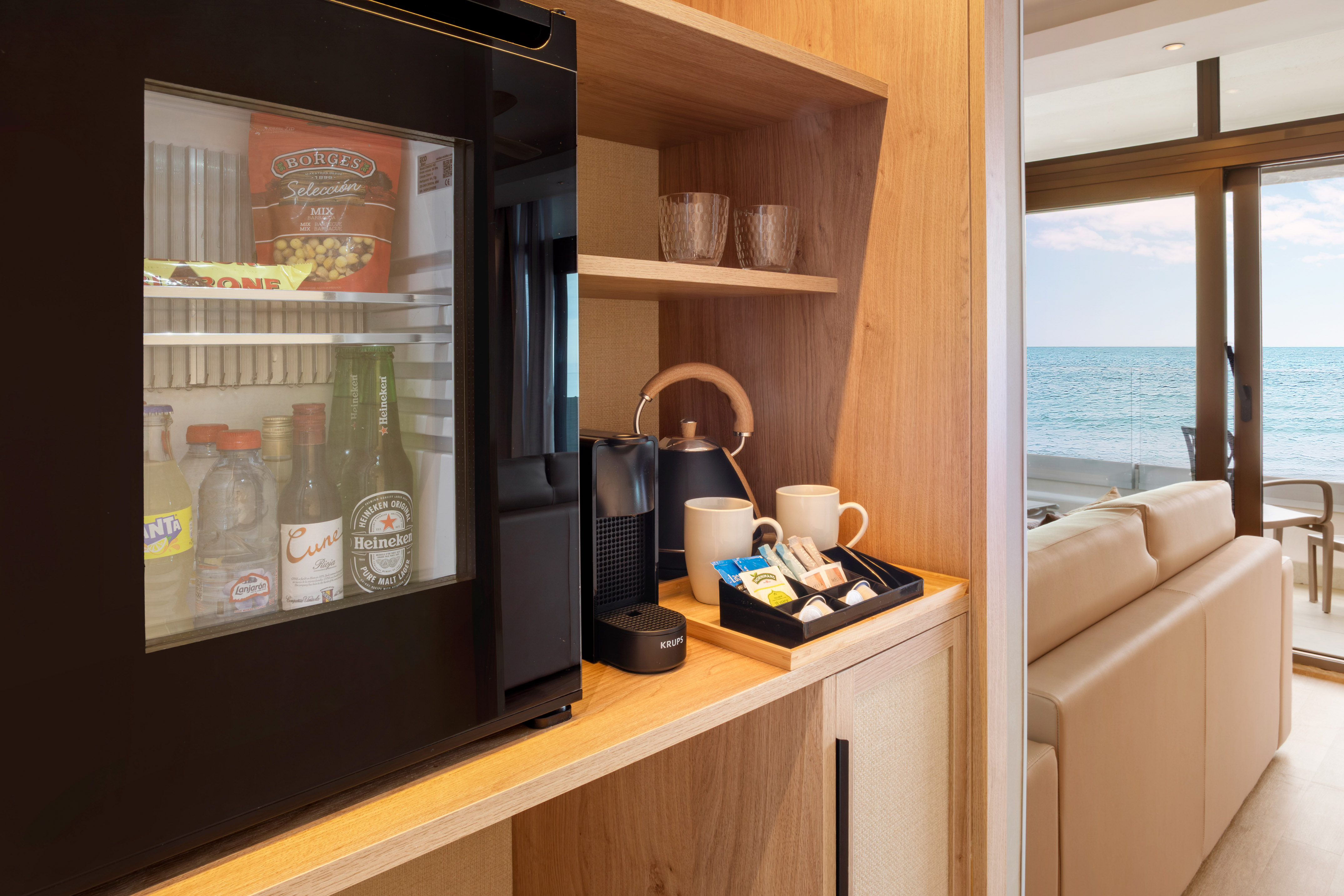Hotel room minibar, coffee station, snacks, and ocean view.