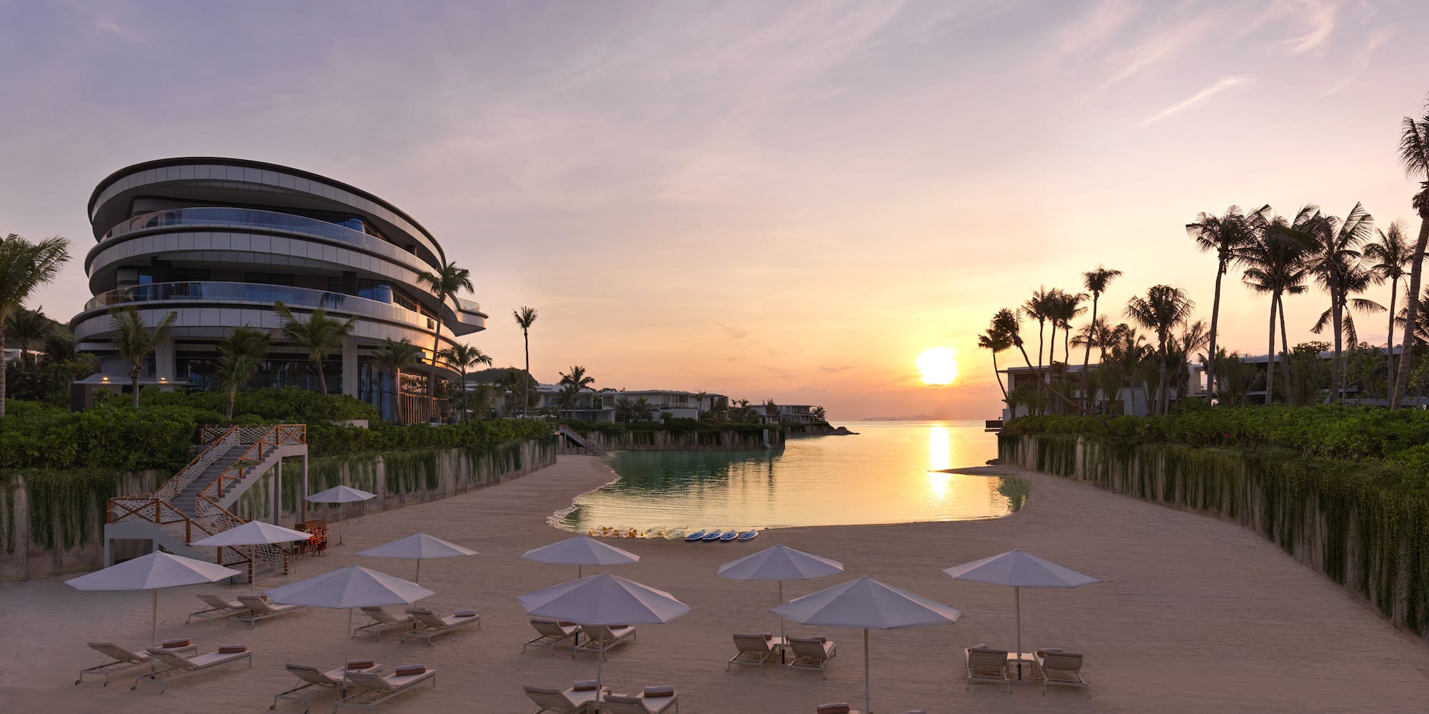 a beach with umbrellas and chairs and a pool in front of a building