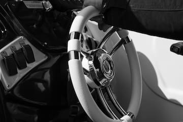 a hand holding a steering wheel