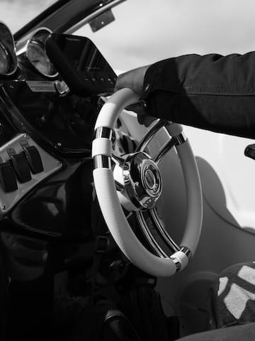 a hand holding a steering wheel