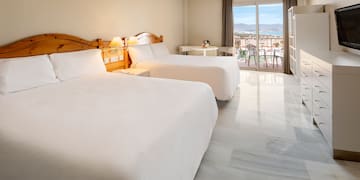 a room with two beds and a balcony