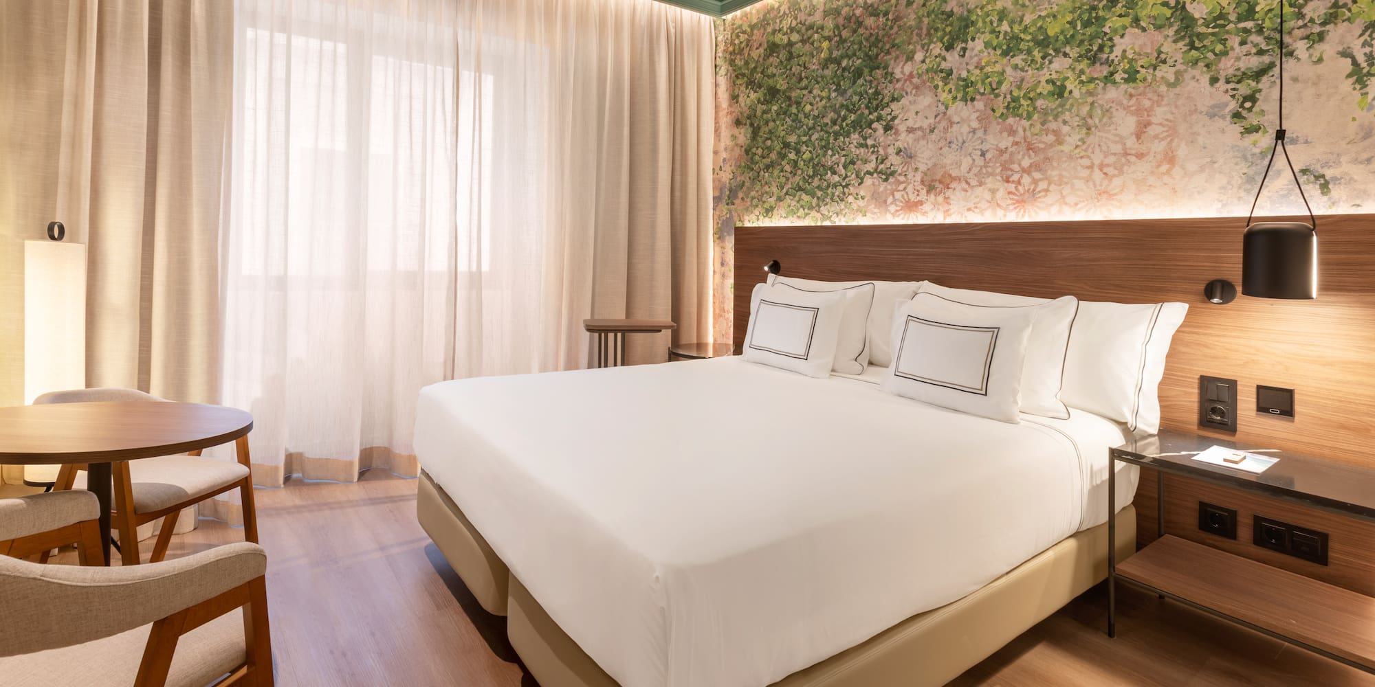 a bed with white sheets and a wood floor