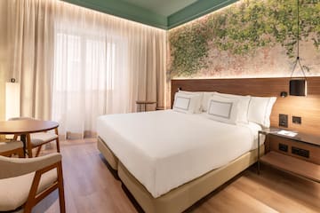 a bed with white sheets and a wood floor