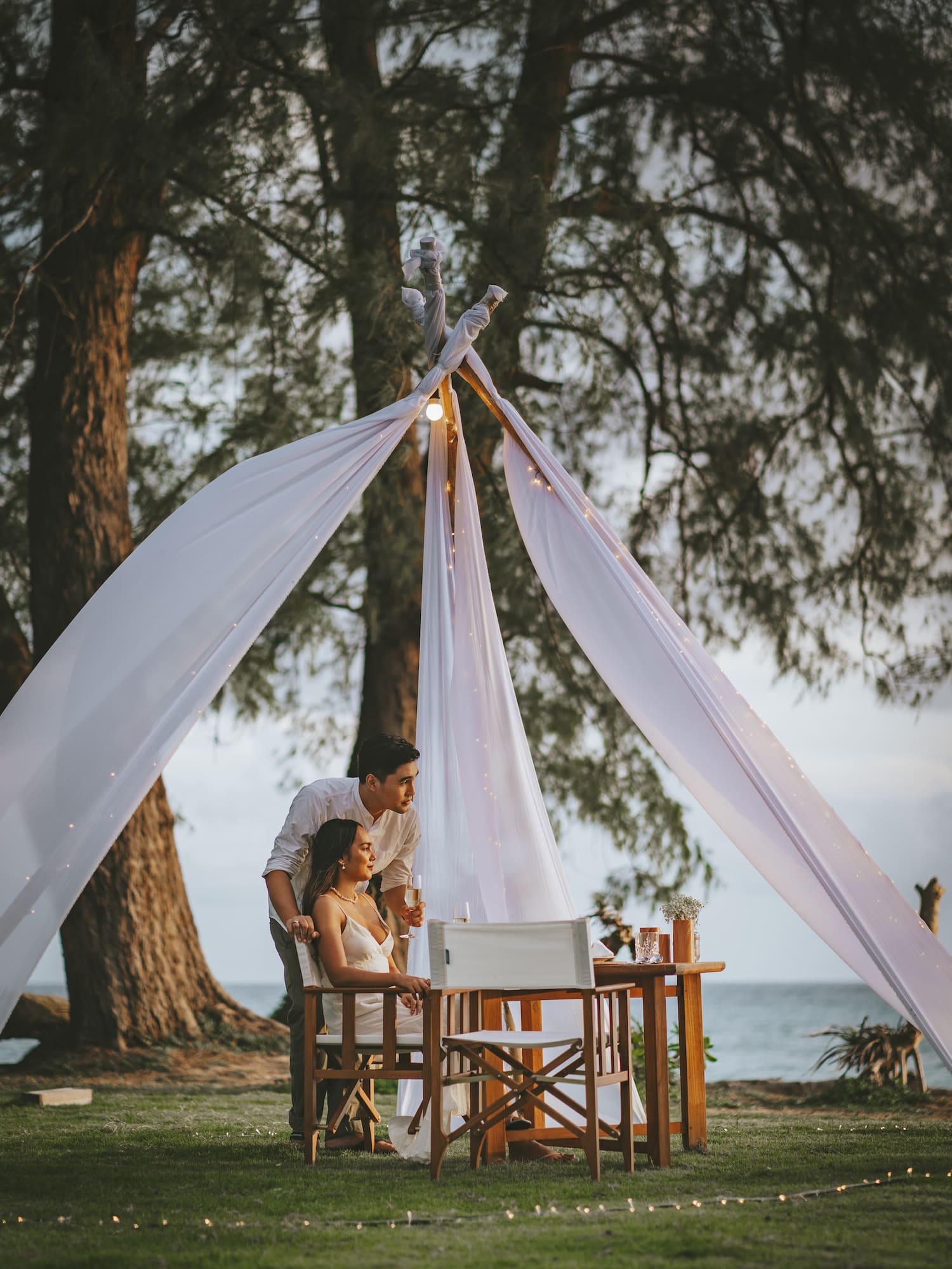 a man and woman sitting under a tent