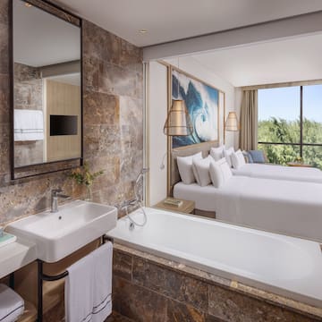a bathroom with a bathtub and two beds