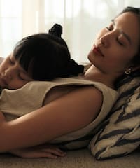 a woman and a child sleeping on a couch