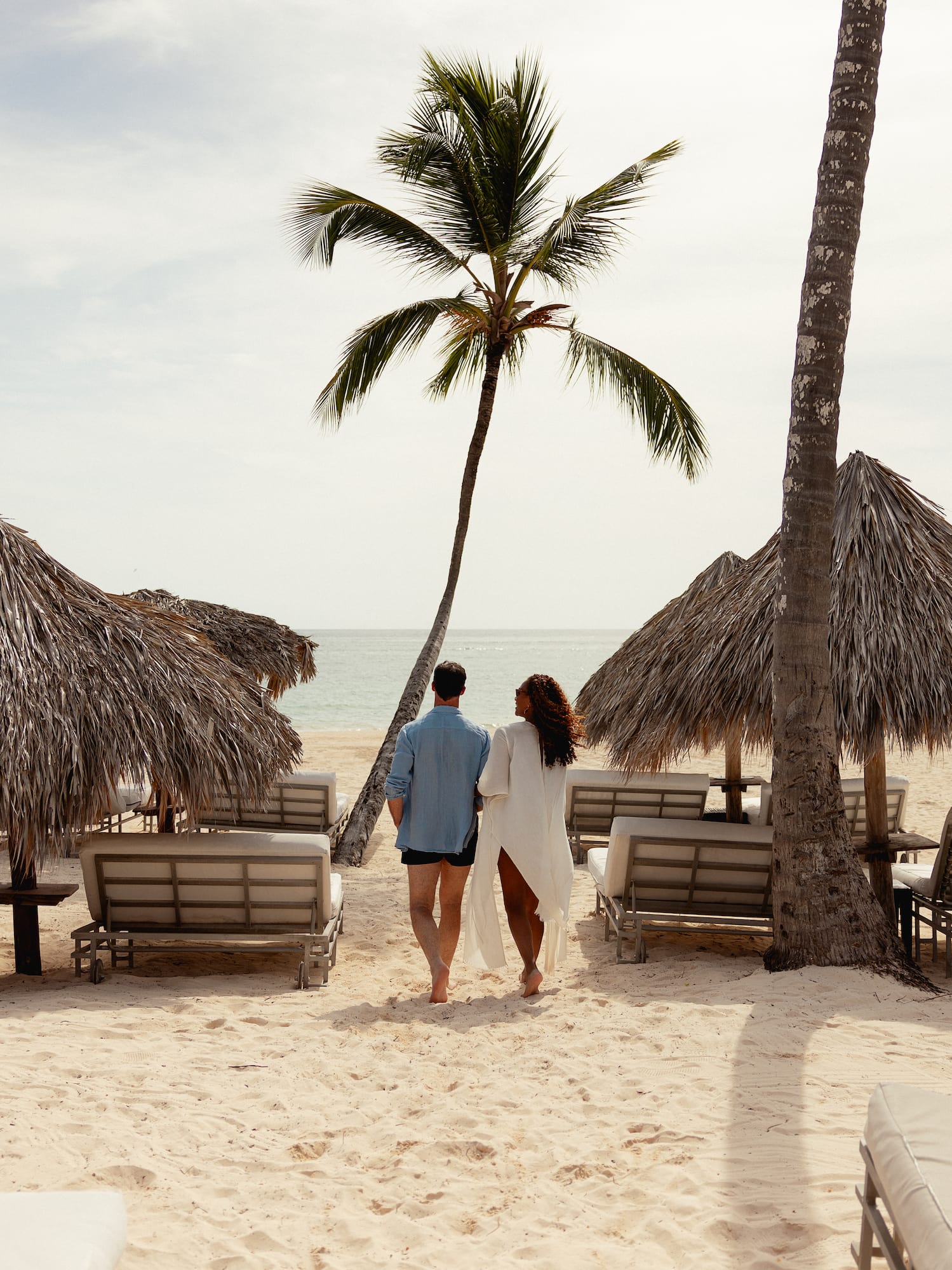 a man and woman walking on a beach
