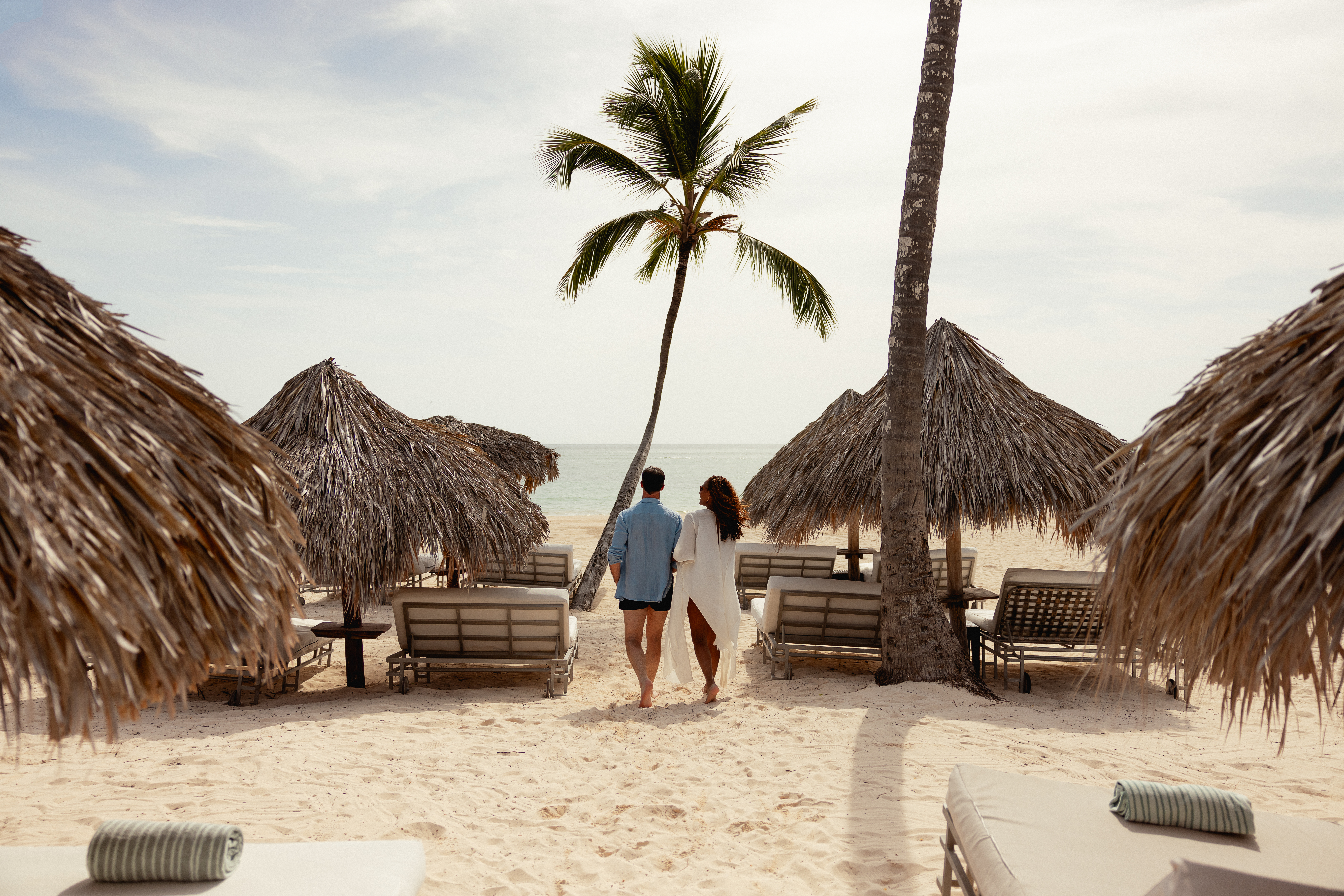 a man and woman walking on a beach