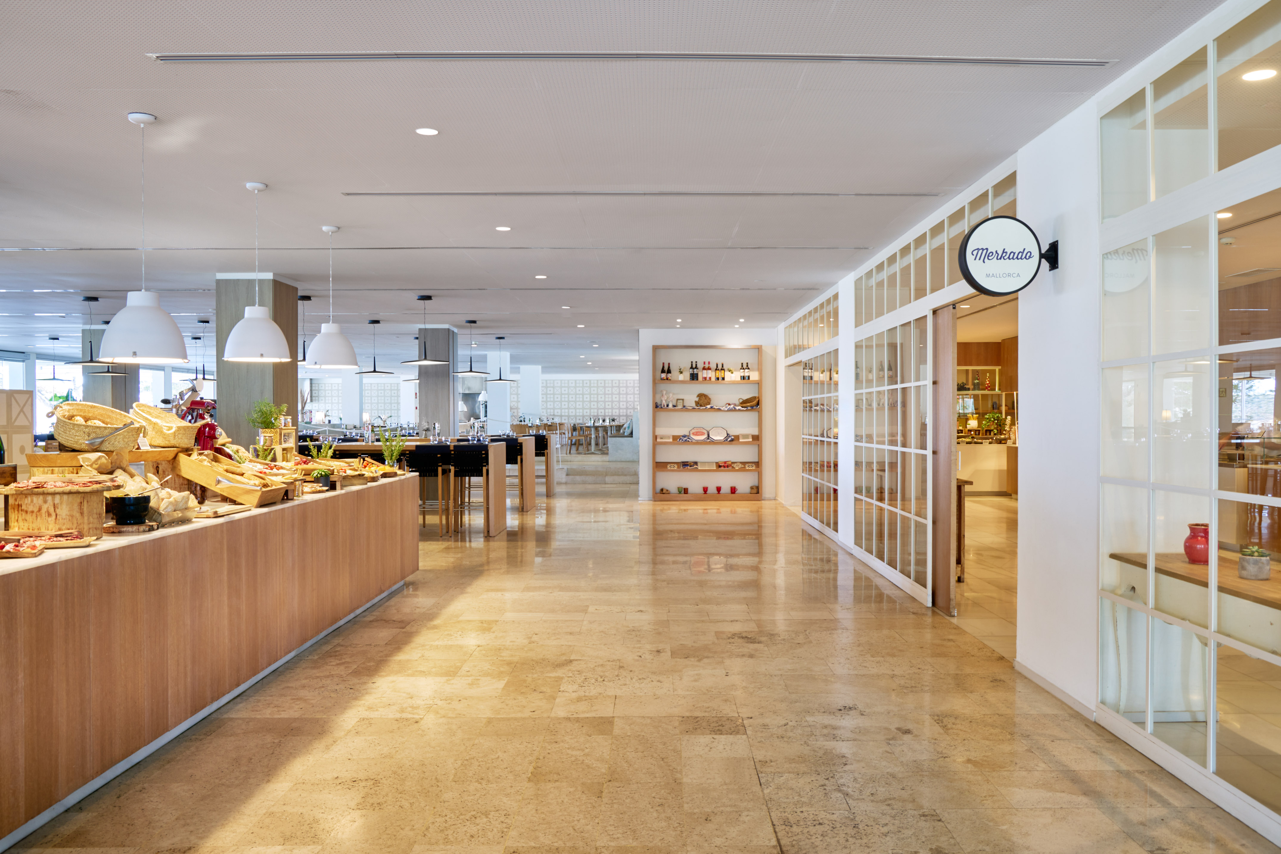 Bright Merkado Mallorca restaurant buffet with modern decor and tiled floor.