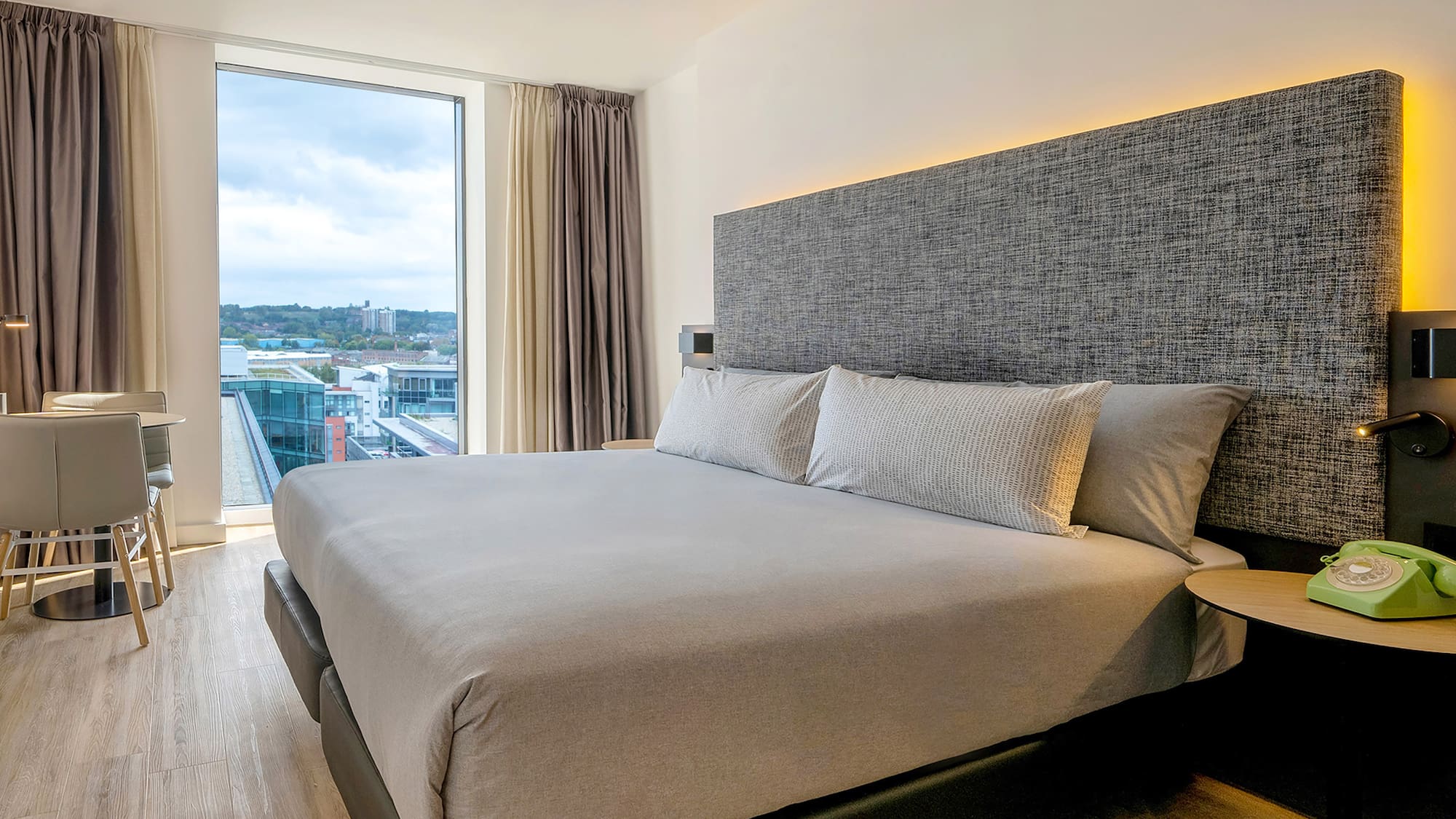 a bed with pillows in a room with a large window