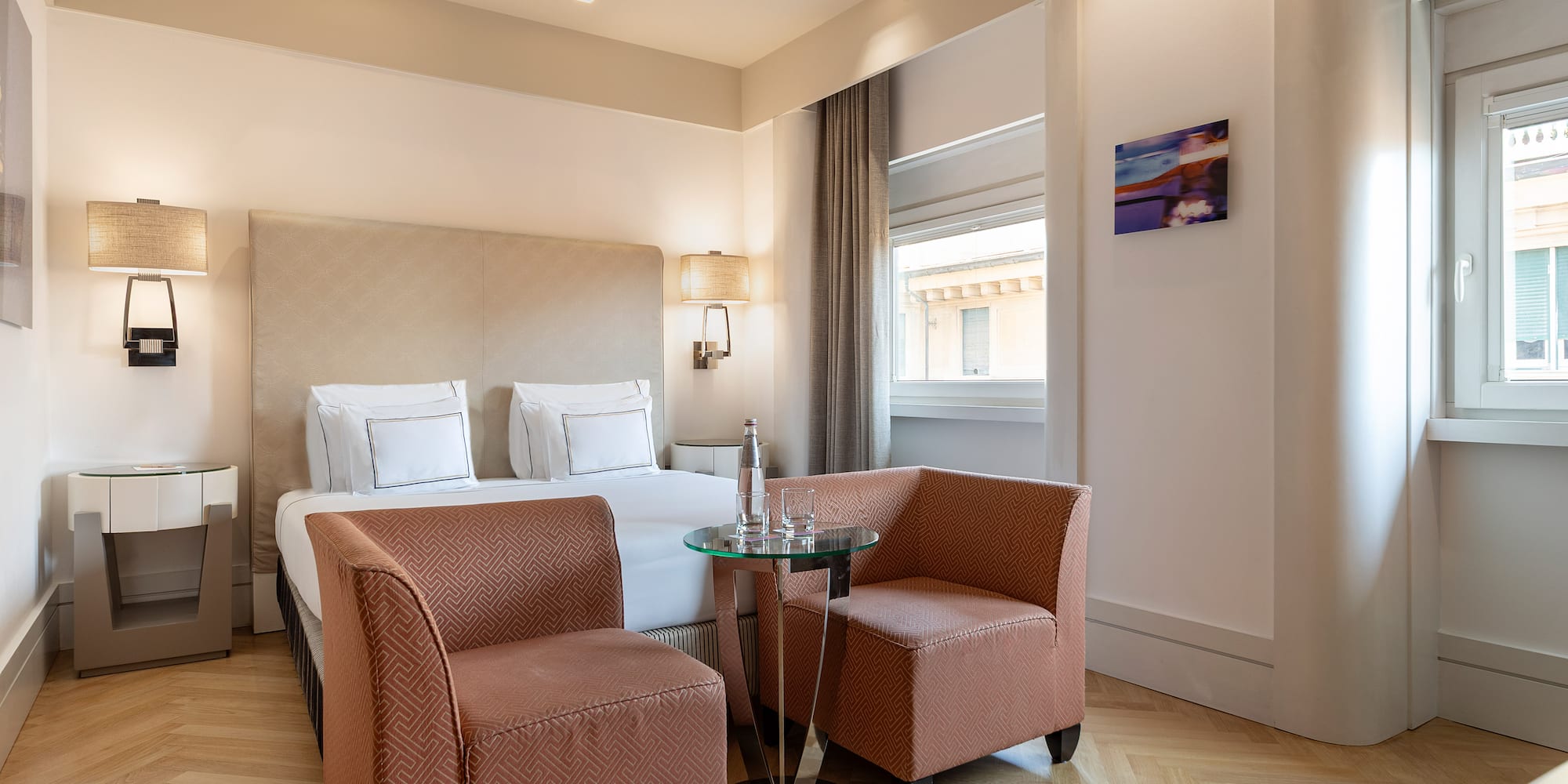 a room with a bed and chairs