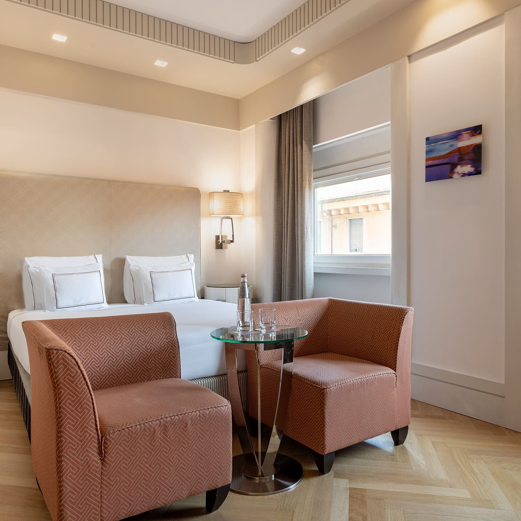 a room with a bed and chairs