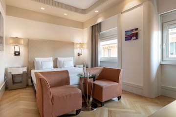 a room with a bed and chairs