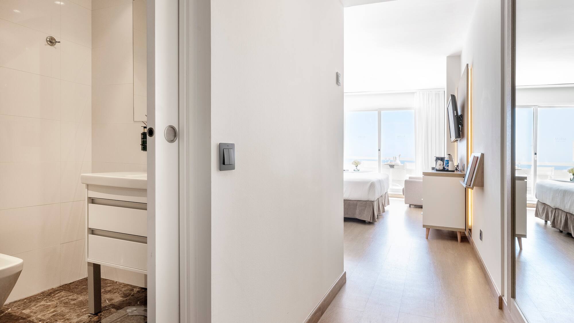 a hallway with a bed and a mirror