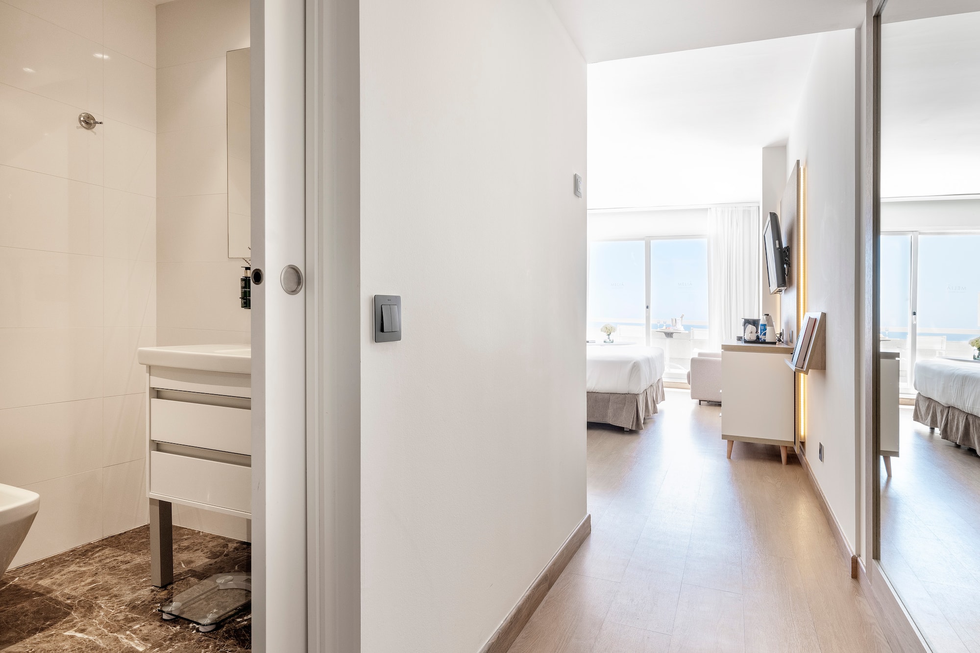 a hallway with a bed and a mirror