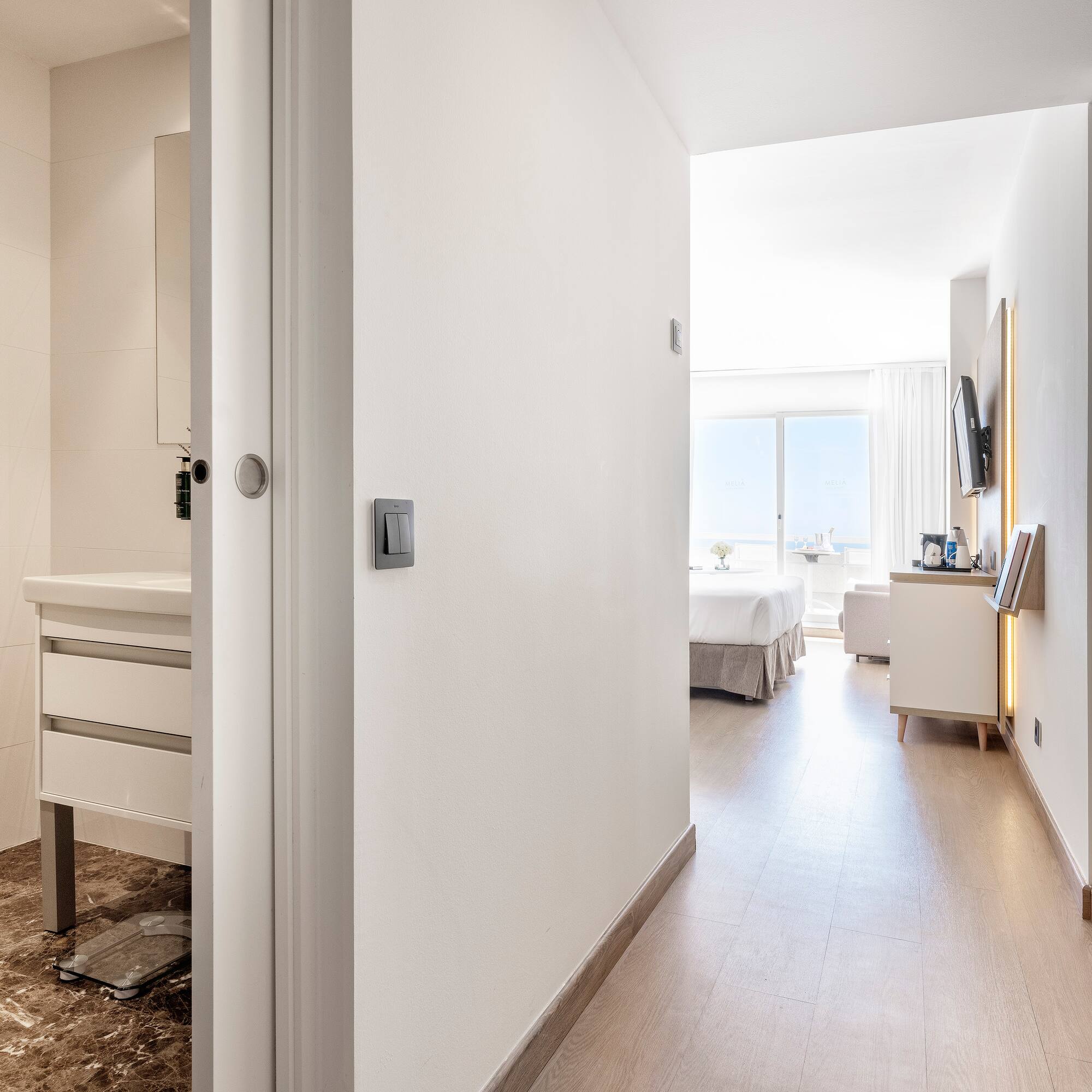 a hallway with a bed and a mirror