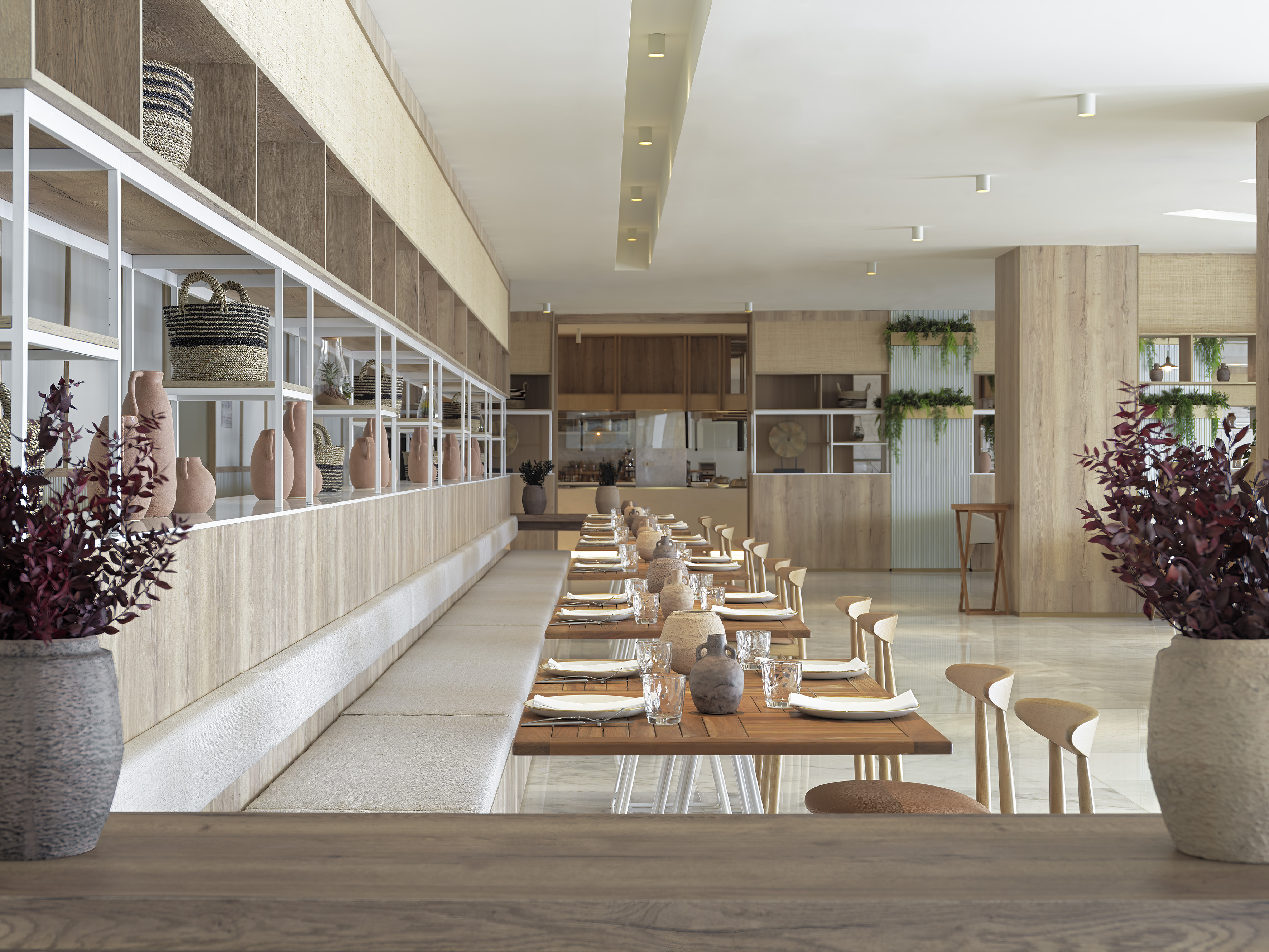 Modern restaurant interior with wooden dining tables, booth seating, and neutral decor.