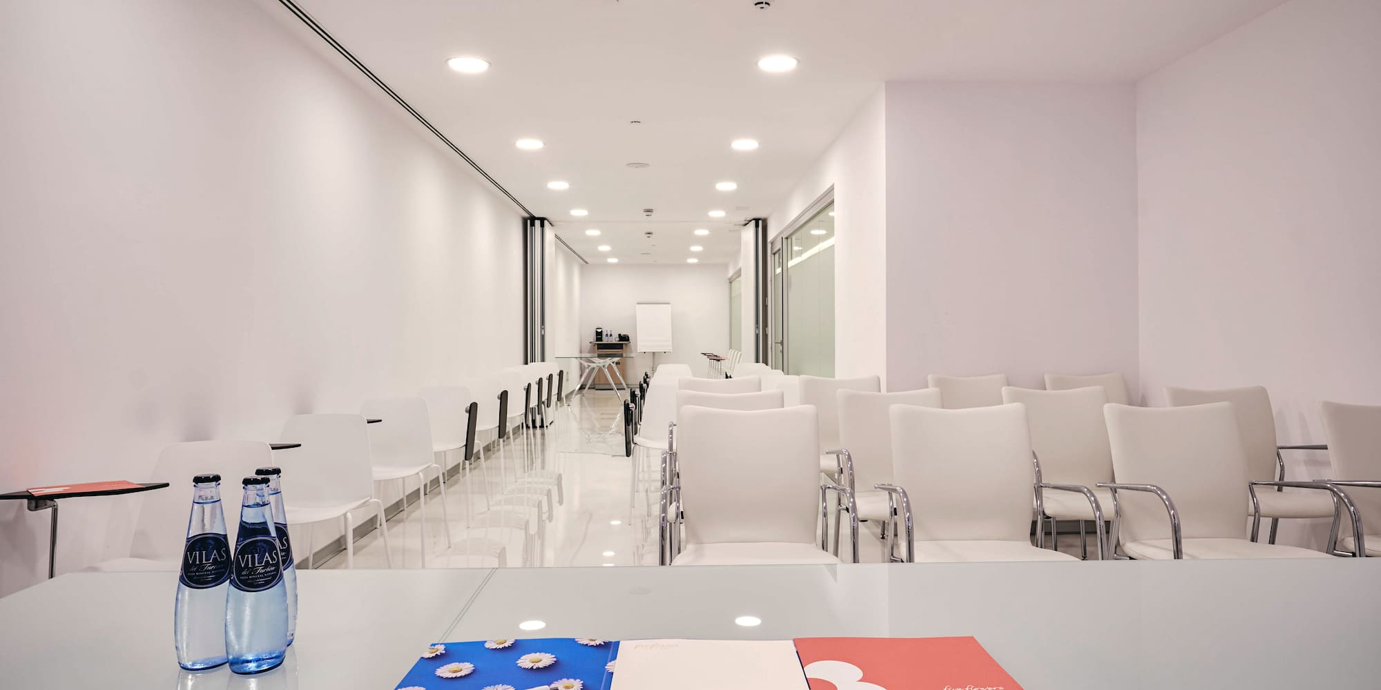 a room with chairs and a table with a pen and a notepad