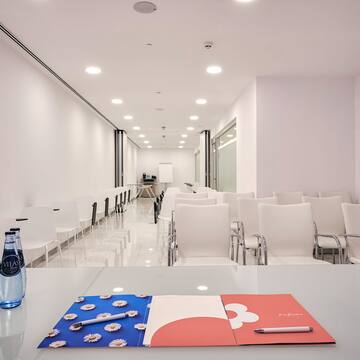 a room with chairs and a table with a pen and a notepad