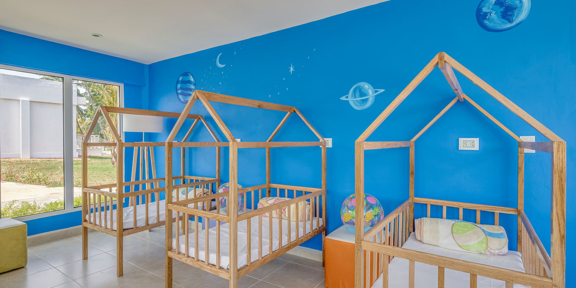 a room with cribs and blue walls