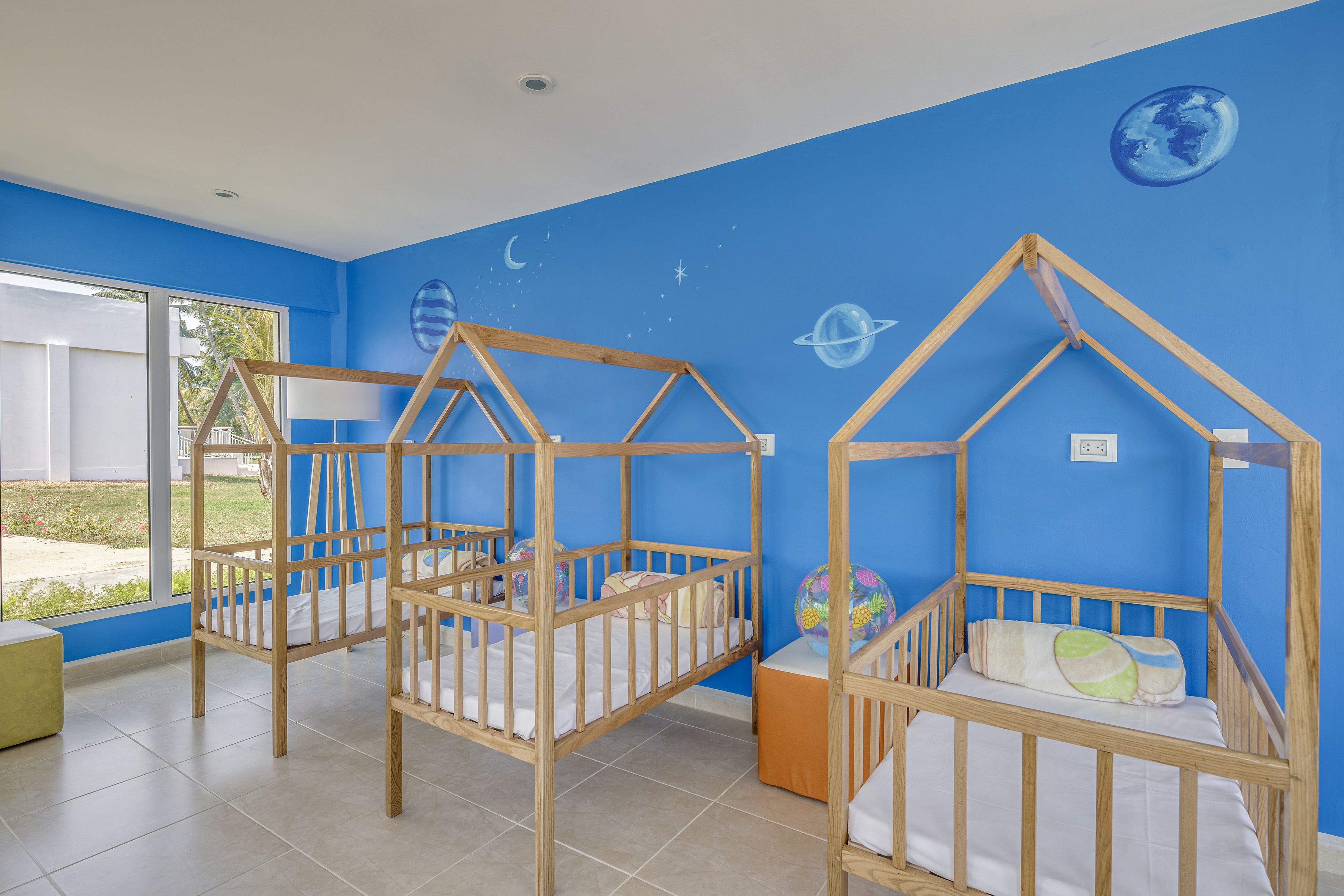 a room with cribs and blue walls