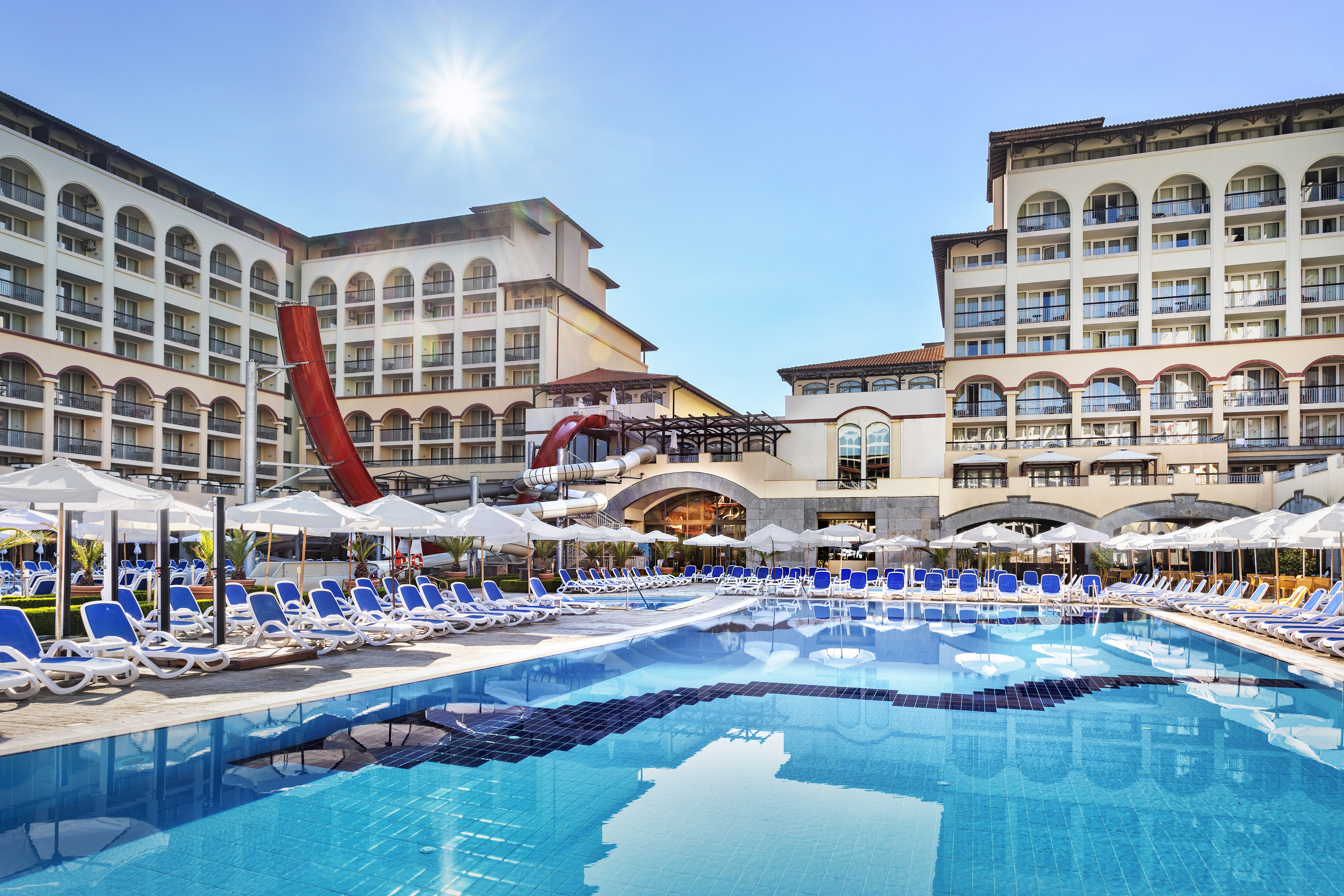 ein Pool mit Rutsche und Sonnenliegen