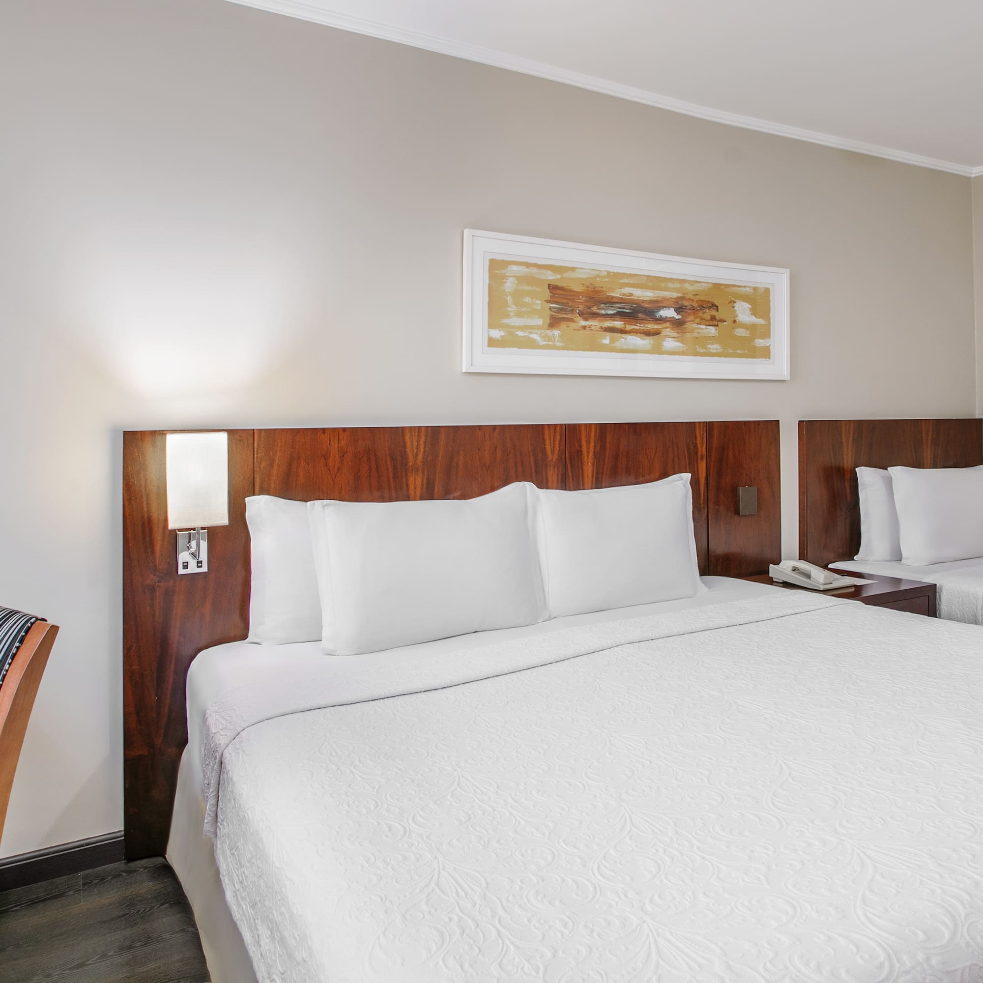 a bed with white sheets and a wood headboard