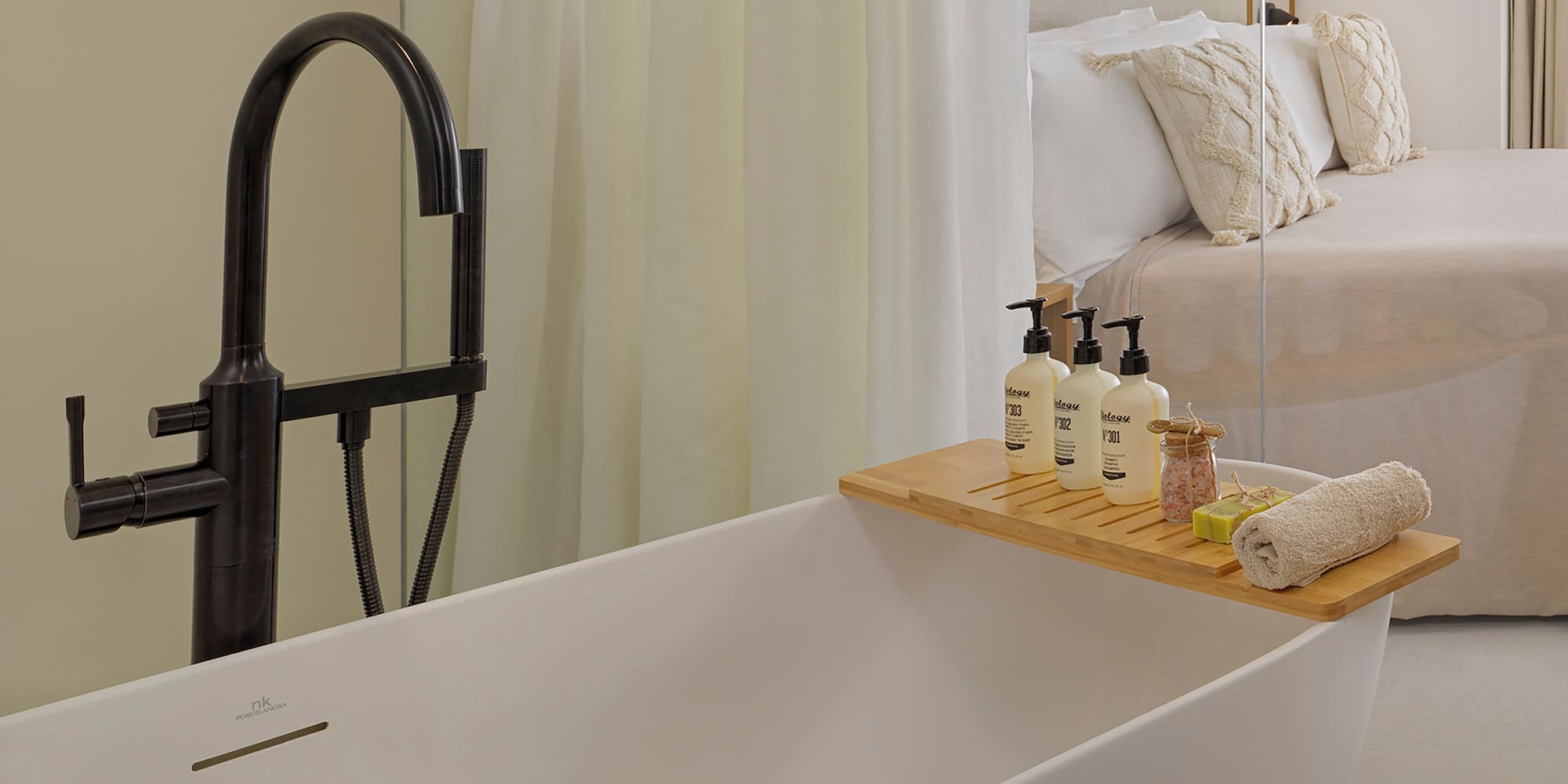 a bathtub with a tray of soaps and other objects on it