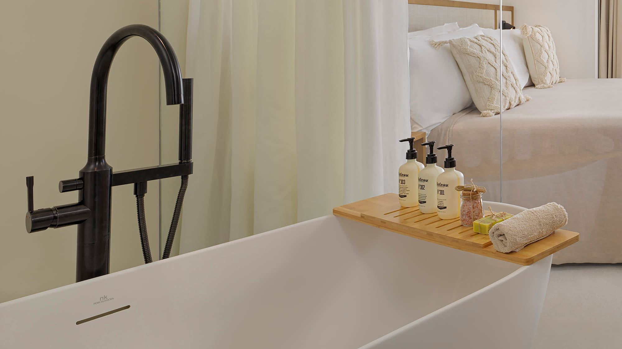 a bathtub with a tray of soaps and other objects on it