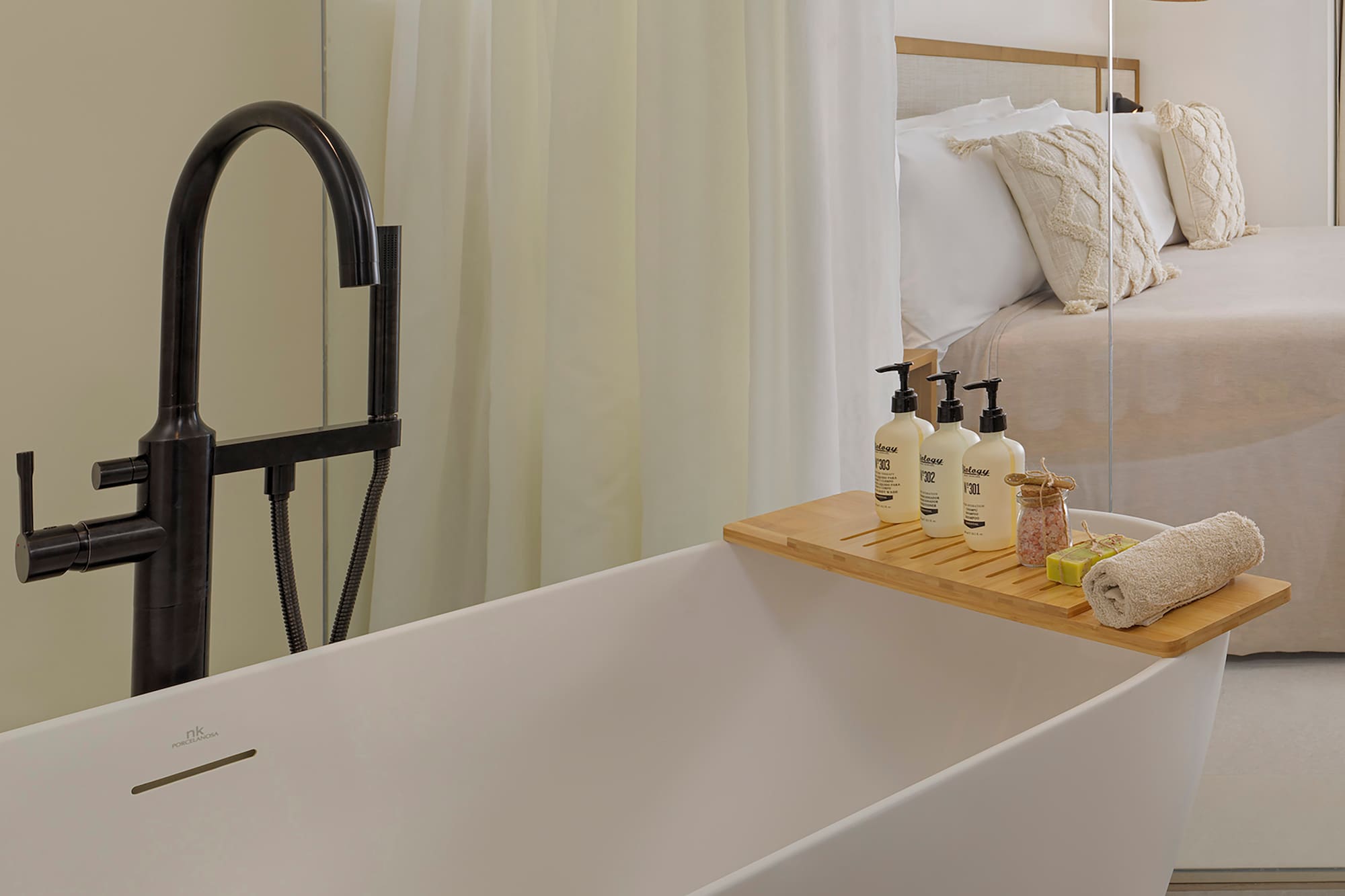 a bathtub with a tray of soaps and other objects on it