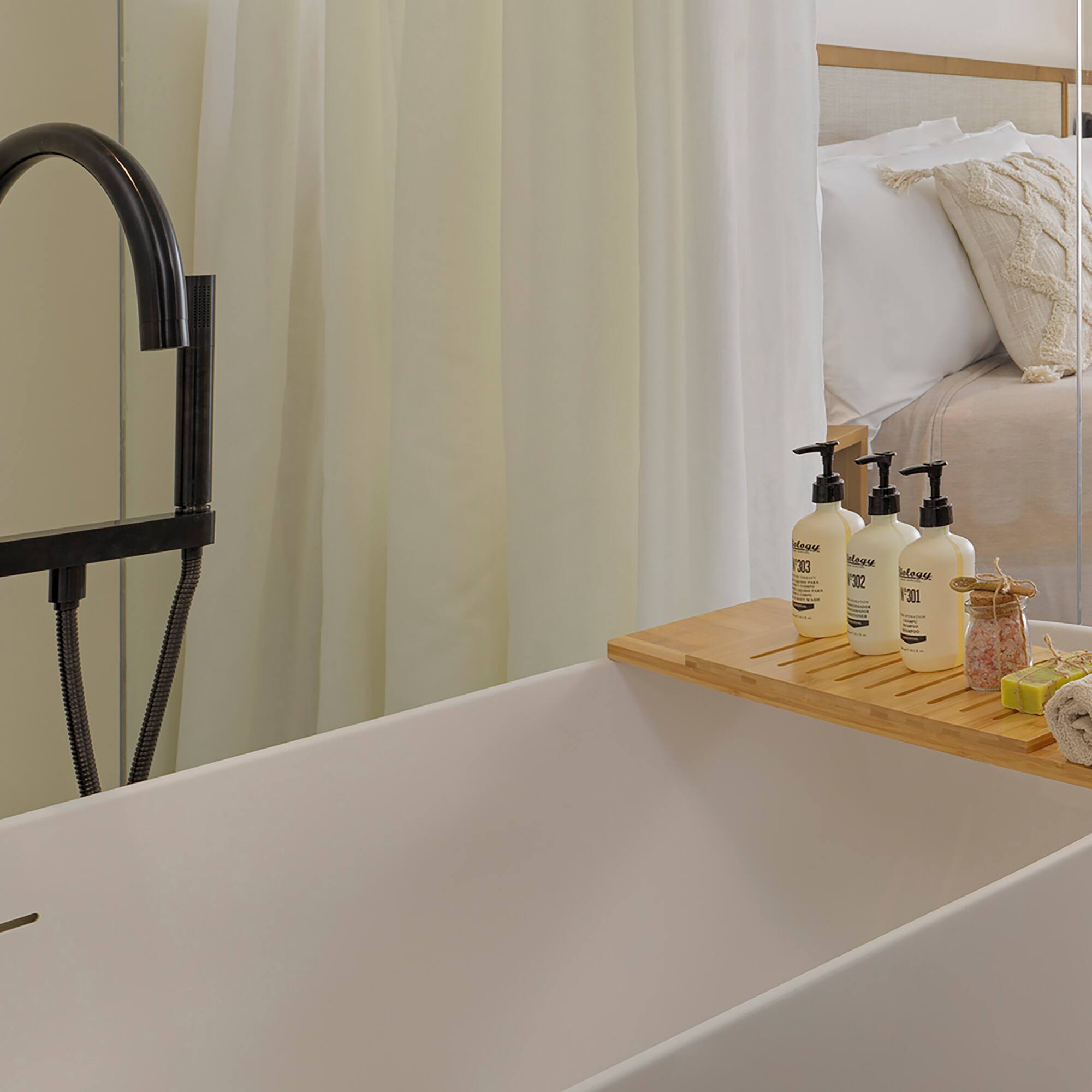 a bathtub with a tray of soaps and other objects on it