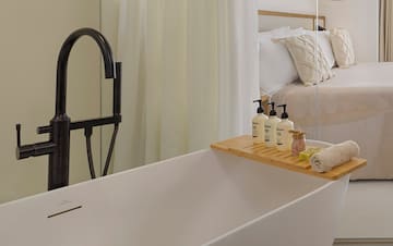 a bathtub with a tray of soaps and other objects on it