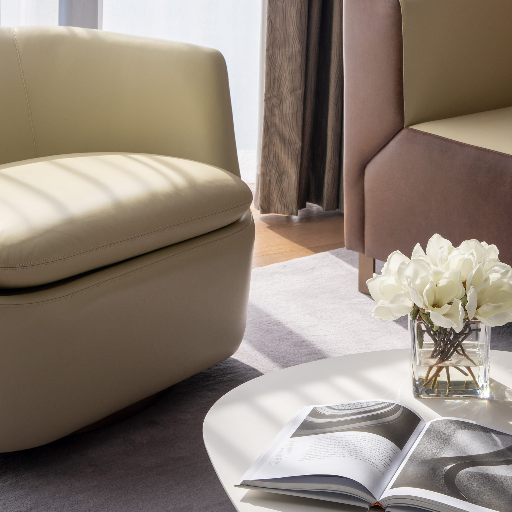 a white table with a vase of flowers and a book on it.