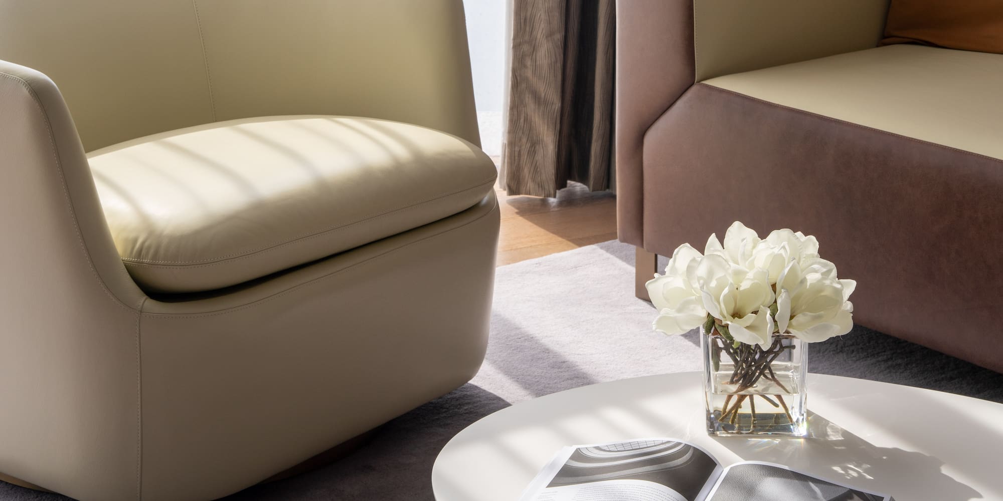 a white table with a vase of flowers and a book on it
