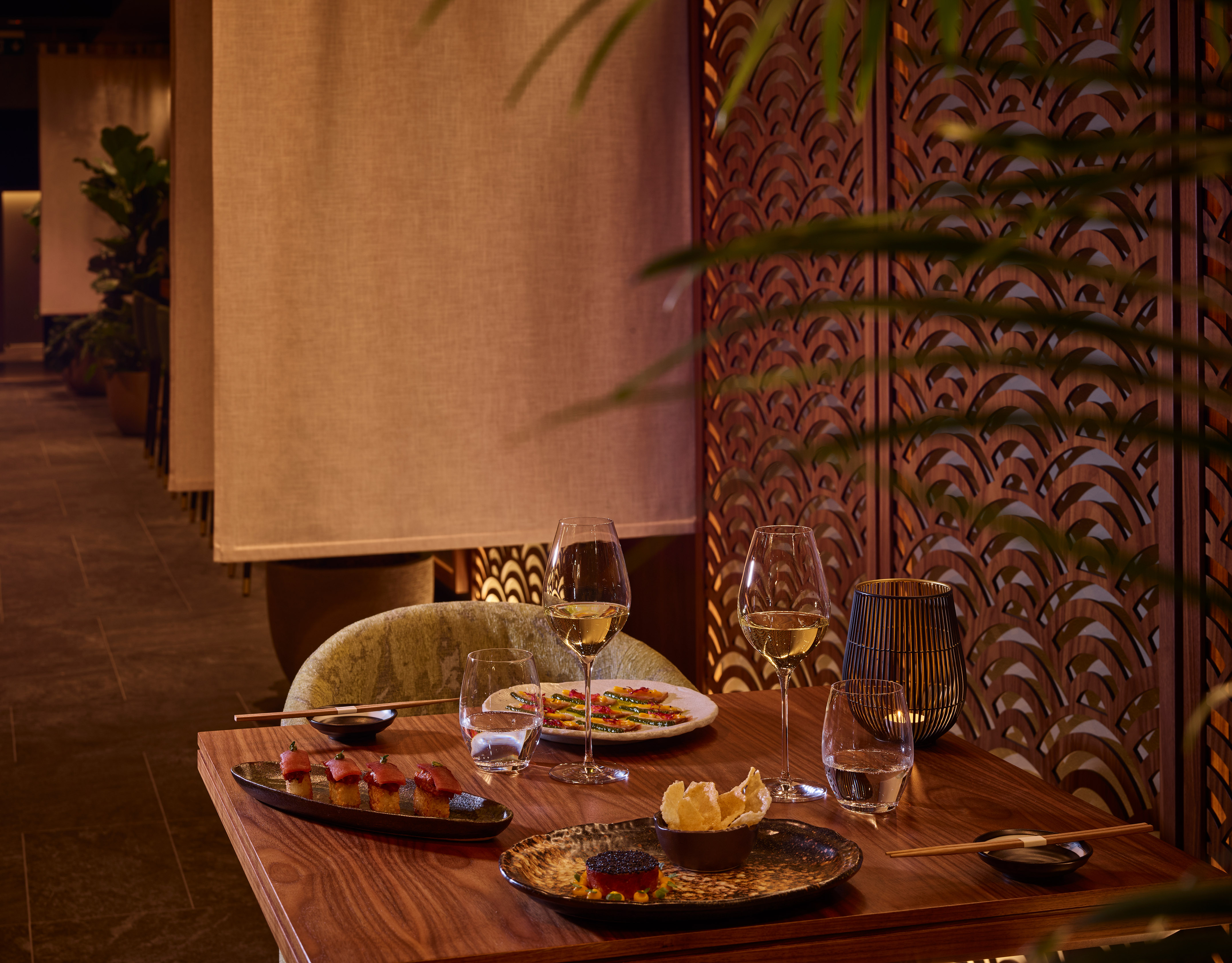 a table with plates of food and wine glasses