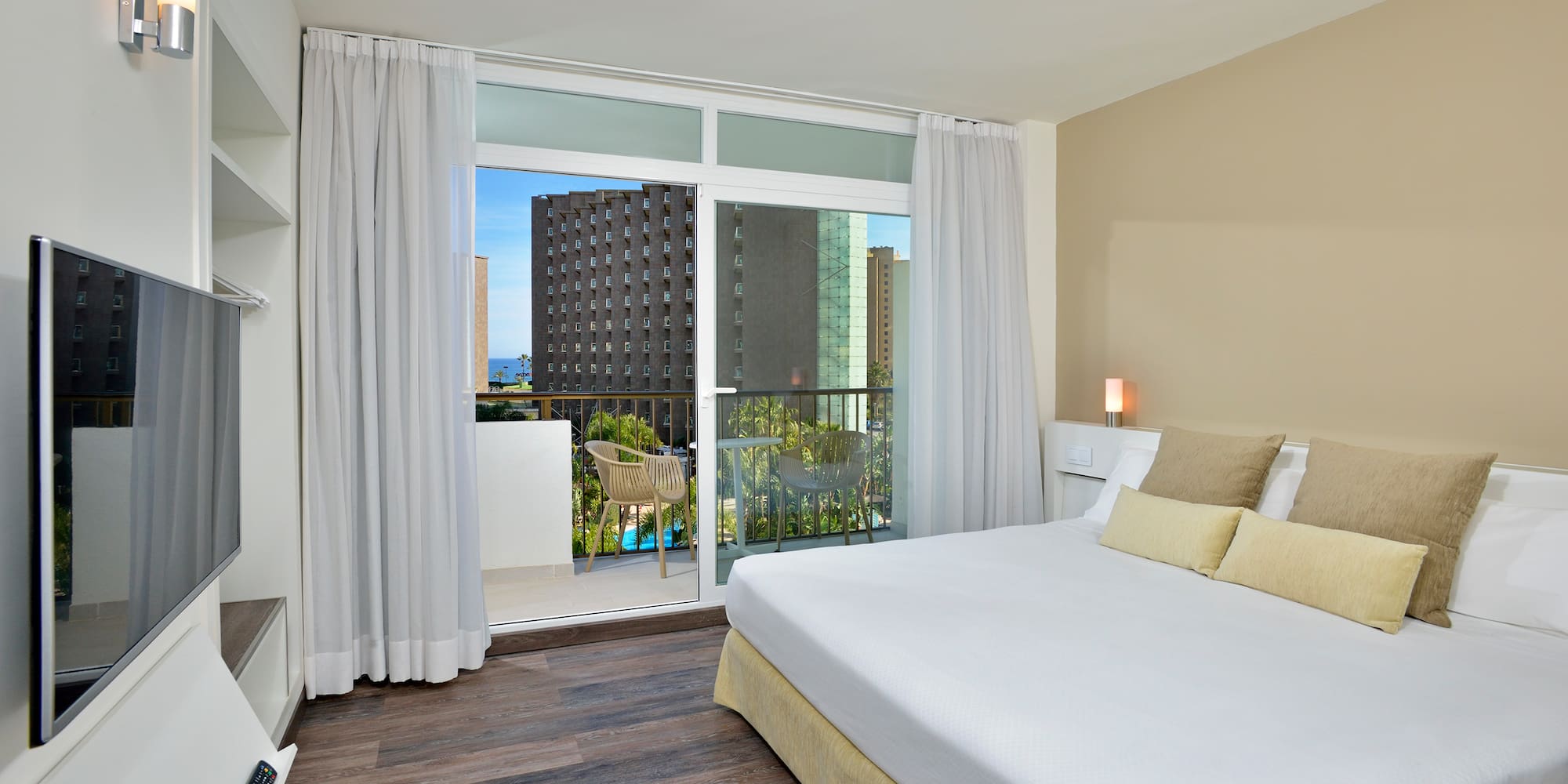 a bedroom with a balcony and a large bed