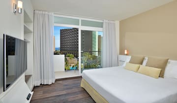 a bedroom with a balcony and a large bed