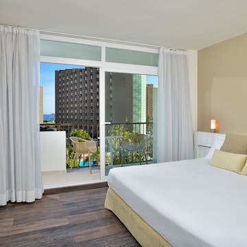 a bedroom with a balcony and a large bed