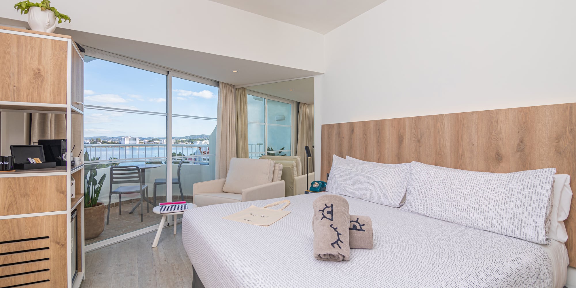 a bed with pillows and towels in a room with a glass door