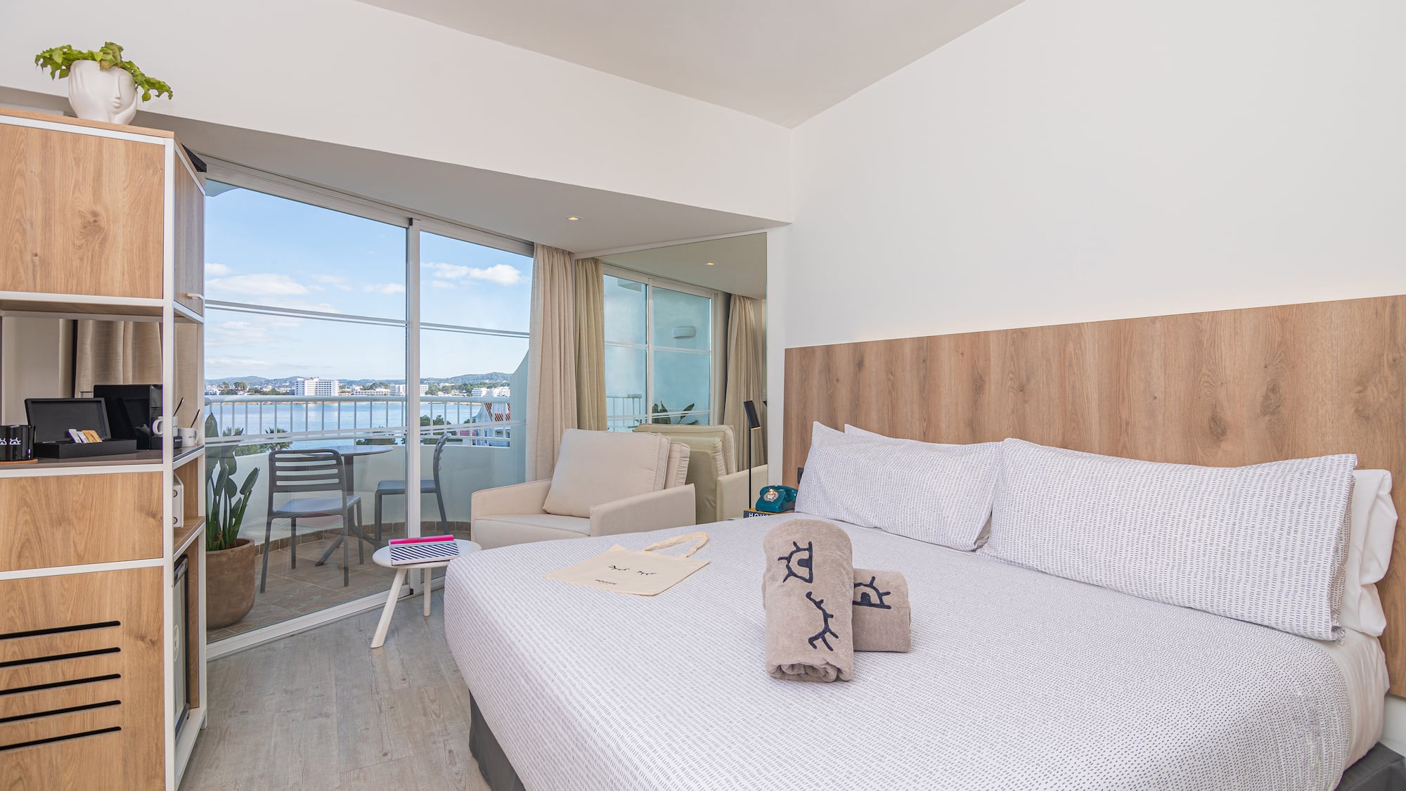 a bed with pillows and towels in a room with a glass door