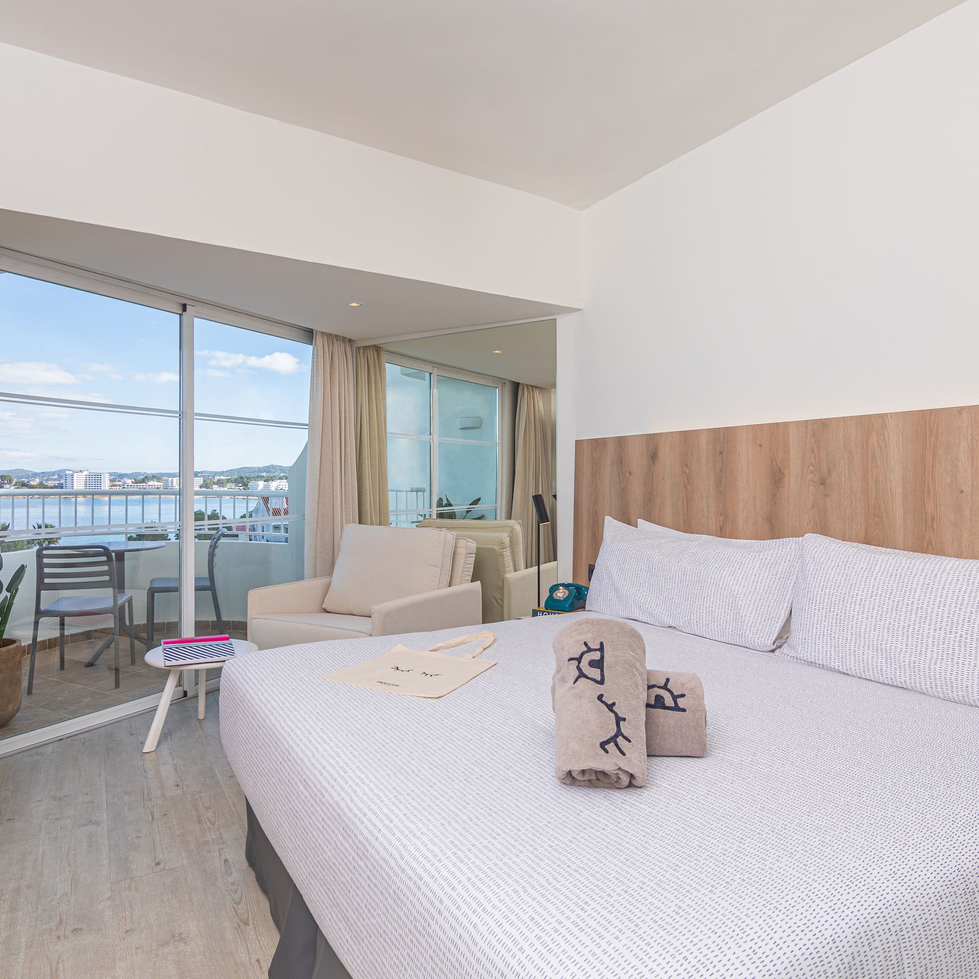 a bed with pillows and towels in a room with a glass door