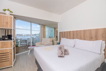a bed with pillows and towels in a room with a glass door